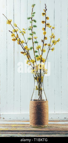 Blumenstrauß aus blühende Zweige der Weide und hartriegel in einer Vase auf dem Tisch auf einem weißen Holz- Hintergrund Stockfoto