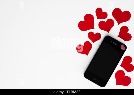 Mockup auf dem Smartphone mit romantischen rote Herzen um ihn herum, alle auf weißem Hintergrund mit kopieren. Happy Valentines. Konzept der Telefon Nachricht mit Gree Stockfoto