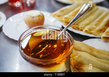 Pfannkuchen mit Käse mit Honig auf einem weißen Teller serviert Stockfoto
