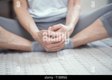 Eine Frau im Alter von über 50 Jahren ist Yoga zu Hause. Stockfoto