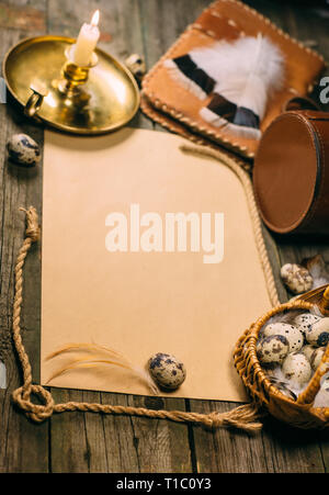 Closeup Körbchen mit Wachteleier und Seil neben gelbes Papier für Text auf rustikalen, mit Holz. Vintage vertikale Hintergrund. Ansicht von oben. Stockfoto
