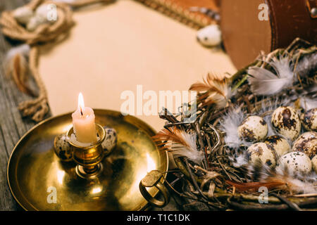 Vintage Hintergrund am rustikalen, mit Holz. Closeup Leuchter und Eier im Körbchen auf Blatt Papier für Text. Stockfoto