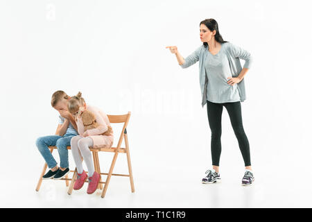 Wütende Mutter ihren Sohn und Tochter zu Hause Schelte. Studio shot der emotionalen Familie. Menschliche Emotionen, Kindheit, Probleme, Konflikte, das häusliche Leben, Beziehung Konzept Stockfoto