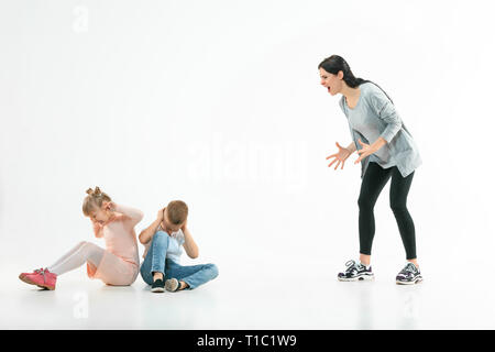 Wütende Mutter ihren Sohn und Tochter zu Hause Schelte. Studio shot der emotionalen Familie. Menschliche Emotionen, Kindheit, Probleme, Konflikte, das häusliche Leben, Beziehung Konzept Stockfoto