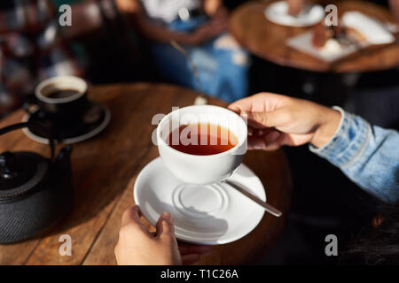 Frau sitzt in einem Café Tabelle Tee trinken. Stockfoto