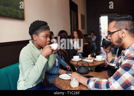 Multiethnischen junges Paar sprechen über Getränke in einem Cafe Stockfoto