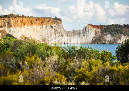 Eine tolle Aussicht aus einer Entfernung auf einen großen Felswand. Bunte Landschaft der schönen mediterranen Natur, mit grünen Bäumen und dem blauen Meer. Stockfoto