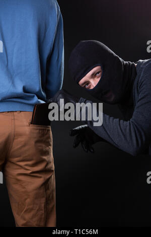 Einbrecher stiehlt das Portemonnaie aus der Tasche in der Tasche. Stockfoto