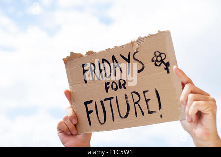 Nahaufnahme eines jungen kaukasischen Mann im Freien mit einem braunen Karton Schild mit dem Text Freitag für zukünftige handschriftlich in Es Stockfoto