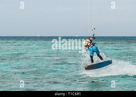 Professionelle Kiter macht das schwieriger Trick auf einem schönen Hintergrund von Sprühen und ocean Oberfläche Stockfoto