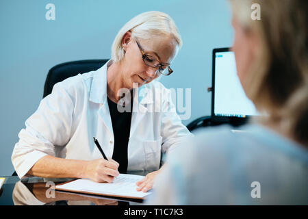 Health Care Worker im Gespräch mit kranken älteren Patienten im Krankenhaus Stockfoto