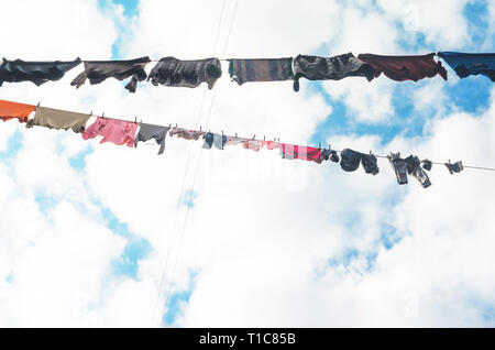 Die Bettwäsche ist auf der Wäscheleine auf dem Hintergrund der blauen Himmel mit Wolken getrocknet. Sonnigen Tag Stockfoto