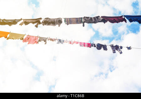 Die Bettwäsche ist auf der Wäscheleine auf dem Hintergrund der blauen Himmel mit Wolken getrocknet. Sonnigen Tag Stockfoto