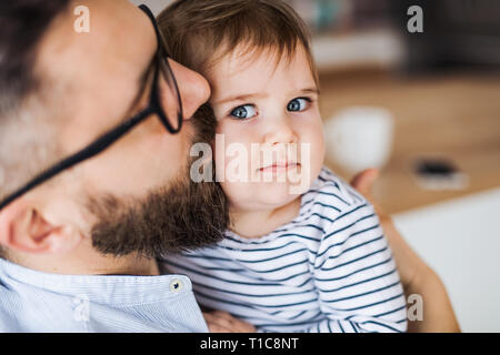 Eine Nahaufnahme Porträt des Vaters mit einem Kleinkind Mädchen zuhause, küssen. Stockfoto
