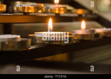 Votiv Kerzen und Gebete für Lieben innerhalb einer christlichen Kirche Stockfoto