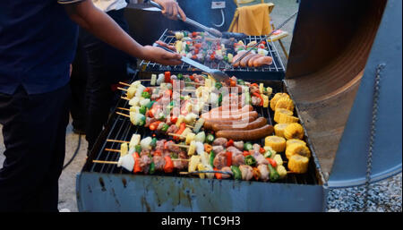 Asiatische Gruppe von Freunden in Außenbereich Garten Grill Lachen mit alkoholfreien Bier Getränke bei Nacht Stockfoto