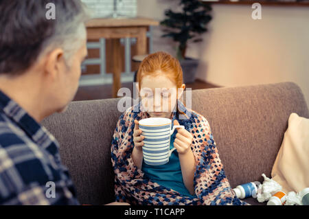 Schönes nettes Mädchen blasen am Kaffee Stockfoto