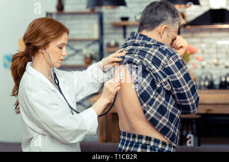 Schöne schwere Arzt über Ihre professionelle Stethoskop Stockfoto