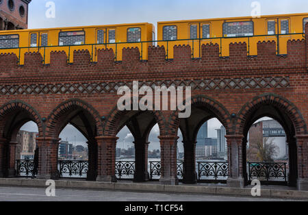 Gelbe u-bahn Autos fahren auf der Oberbaunum Brücke links Friedrichshain und Kreuzberg, Berlin, Deutschland Stockfoto