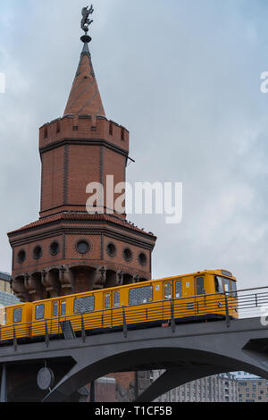 Der gelbe Berliner U-Bahn fahren auf der Oberbaunum Brücke, doppelstöckigen Brücke über die Spree, es links Friedrichshain und Kreuzberg, Deutschland Stockfoto