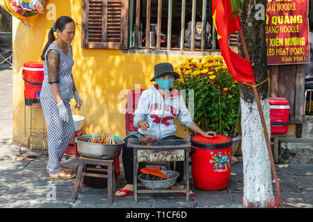 Frau vorbereiten zu kochen Kebabs eine spieße an einer Küche in der Seitenstraße von Hoi An, Quang Nam, Vietnam, Asien Stockfoto