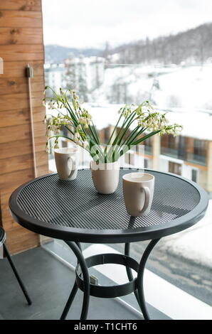 Schneeglöckchen und trinken Becher auf dem Balkon, im Winter Stockfoto