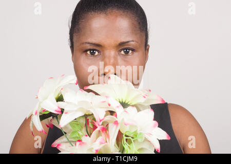 Fröhliche Frau in einem schwarzen Kleid mit einem schönen Blumenstrauß zum Valentinstag Stockfoto