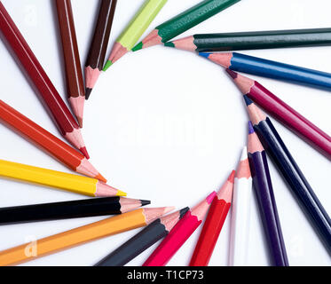 Bunte Bleistifte aus Holz bilden einen Kreis auf einem weißen Tisch Stockfoto