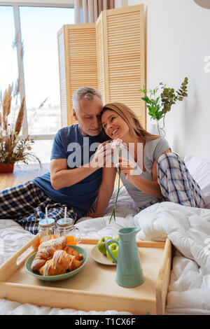 Frau Schiefen auf die Schulter ihres Mannes Frühstück im Bett Stockfoto