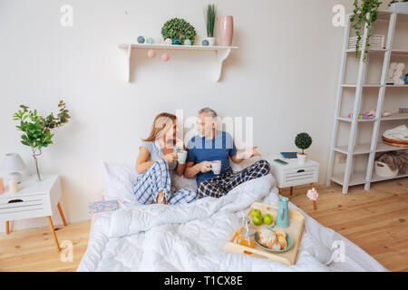 Paar trinken Kaffee am Morgen im Bett und Gespräch Stockfoto