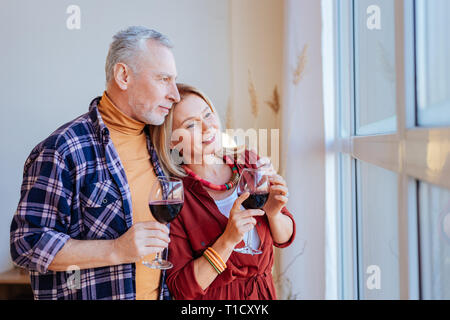 Mann tragen orange Polokragen seine zarten Frau umarmen Stockfoto