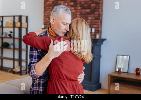 Grauhaarige bärtigen reifer Mann tanzen mit seiner liebevollen Frau Stockfoto