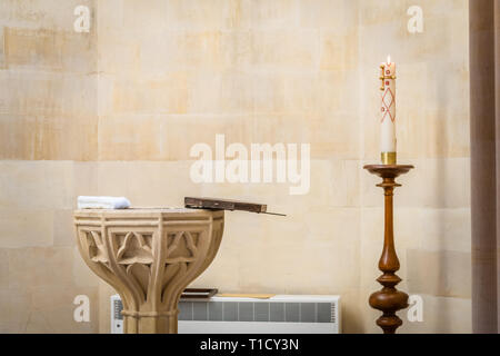 Vor der Taufe in der Arundel Cathedral, West Sussex, England, Großbritannien, wurde eine Taufbecken und eine brennende Kirchenkerze geöffnet Stockfoto