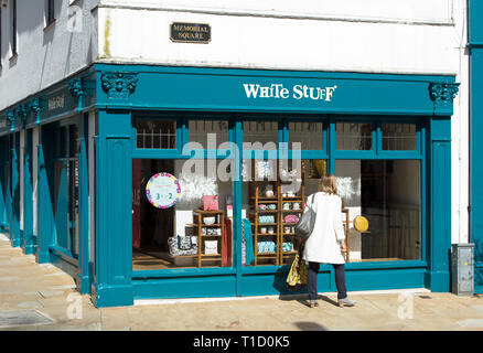 Eine Frau schaut in ein Fenster eines Zweiges der Mode und Lifestyle Händler weiße Zeug, in Kingston upon Thames, Surrey, England Stockfoto