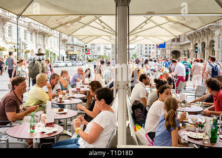 Menschen essen Sachertorte im Freien im Hotel Sacher an einem Sommertag in Wien, Österreich. Stockfoto