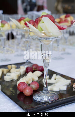 Obstsalat in ein hohes Glas auf einem Schneidebrett, gemischtes Obst Salat im Glas, gesunde Desserts. Stockfoto
