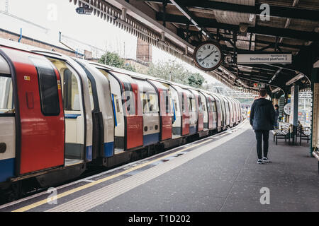 London, UK, 16. März, 2019: die Menschen hinter den Zug im Freien auf der Plattform der Golders Green Tube Station. Die Londoner U-Bahn ist die älteste und Stockfoto