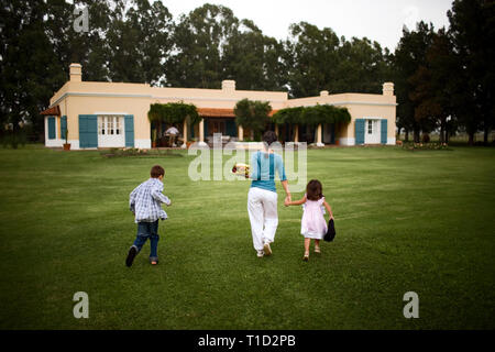 Ansicht der Rückseite eine Mutter auf dem Weg zu ihrem Haus. Stockfoto