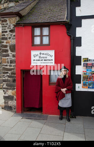 Dame gekleidet in traditionelle walisische Kostüm außerhalb das kleinste Haus in Großbritannien in Conwy in Nordwales Stockfoto