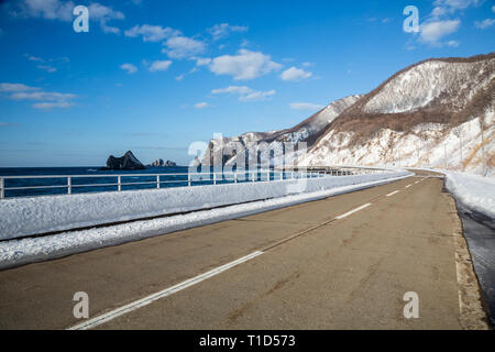 Straße um die zerklüftete Küste des Japanischen Shakotan Penninsula auf der nördlichen Insel Hokkaido. Ausblicke auf Meer, Klippen, schneebedeckte Berge. Stockfoto