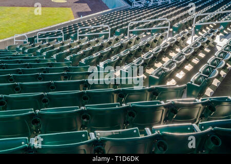 Stufen der Sitzplätze für Zuschauer auf eine Sportarena. Stufen der Sitze mit Cupholder für Zuschauer auf eine Sportarena. Hell Grün gepflegten Rasen kann. Stockfoto