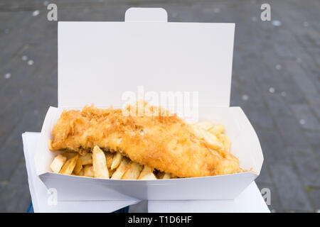 Fisch und Chips auf meinem Schoß aus Nr. 1 Fish & Chips Shop in Cromer, North Norfolk, England ausgeglichen. Stockfoto