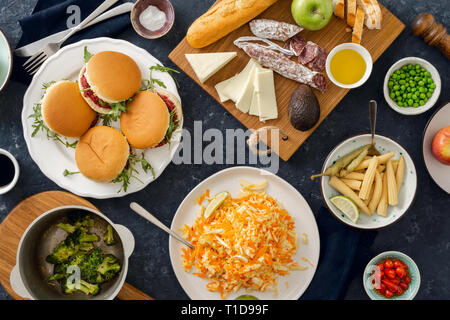 Sommer Party Food Konzept top anzeigen. Verschiedene Lebensmittel auf dem Tisch flach. Vegetarische Burger mit verschiedenen Lebensmitteln. Vegetarische Kost ist nicht nur Stockfoto