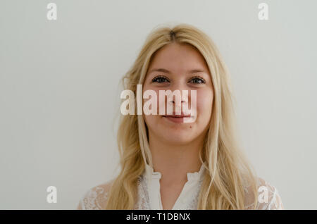 Portrait von fröhlichen schöne Frau mit blonden Haaren, grünen Augen und einnehmenden Lächeln im Studio posiert auf weißem Hintergrund. Menschen, Glück, Emotionen Stockfoto