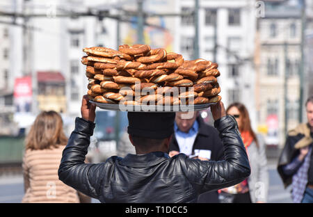 Türkische Straßenhändler, die eine Platte mit Simit Sesam Brot auf dem Kopf Stockfoto