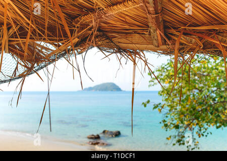 Tropischen Sandstrand, Meer Blick durch das Stroh Dach Dach. Reisen Urlaub Sommer. Stockfoto