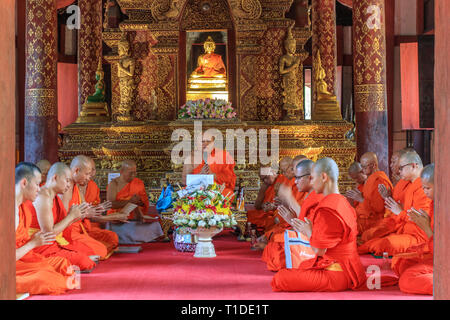 Eine Gruppe von Mönchen, die im Gebet im Innern des Wat Pra singen Tempel versammelt Stockfoto