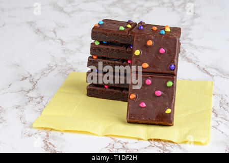 Stapel von chocolate fudge Brownies auf gelb serviette Stockfoto