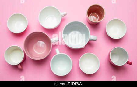 Kaffeetassen in Rosa. Leere Kaffeetassen weiss und rosa Farbe gegen rosa Hintergrund, Ansicht von oben Stockfoto