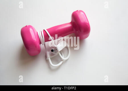 Weißen Sport wireless In-Ear-Kopfhörer mit rosa Hantel auf weißem Hintergrund Stockfoto